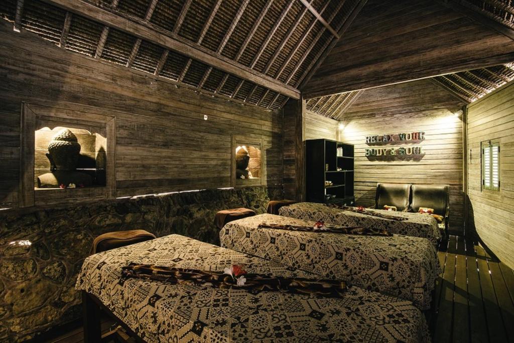 a hotel room with four beds and a bar at Dream Beach Huts in Nusa Lembongan