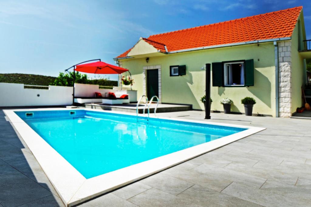 a swimming pool in front of a house at House Lucia in Brštanovo