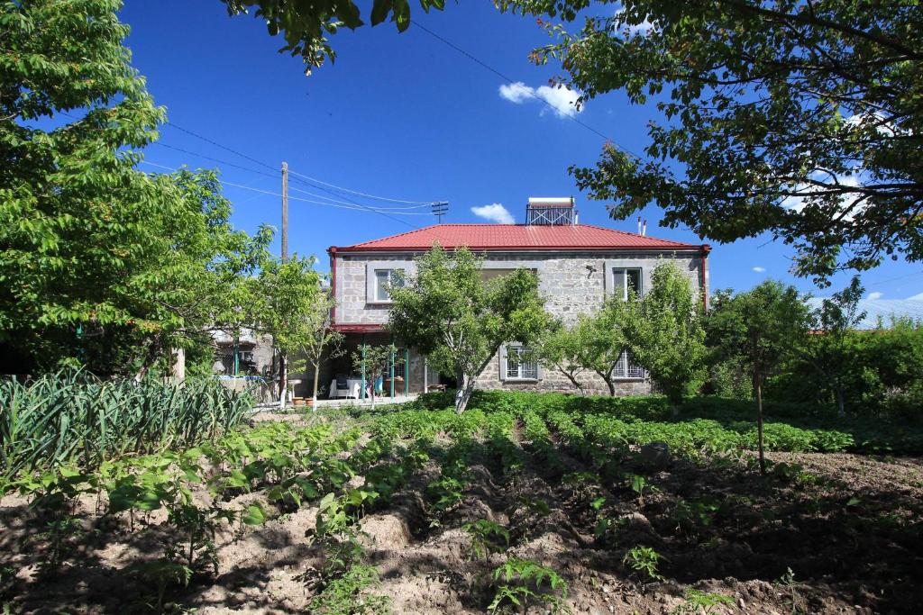 een oud huis met een rood dak en bomen bij Karin's B&B in Sisian