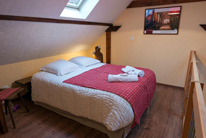 1 dormitorio con 1 cama con toallas en Au gre des chateaux, en Goxwiller