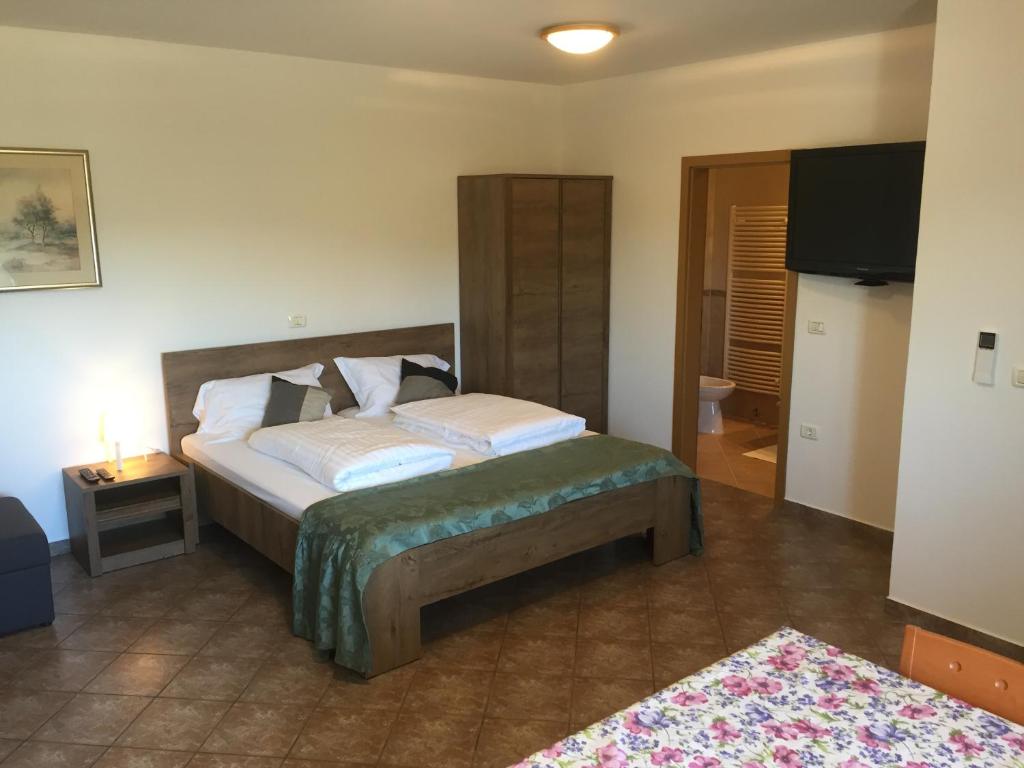 1 dormitorio con 1 cama y TV en Apartma Valmarin, en Spodnje Škofije
