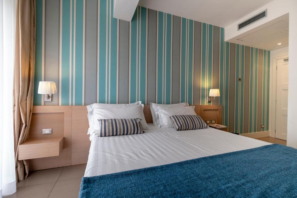 A bed or beds in a room at Le Rose Suite Hotel