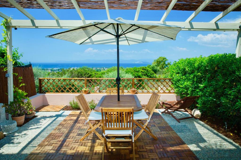 a patio with a table and chairs and an umbrella at Casa Vista with spectacular view and gas BBQ in Capitana