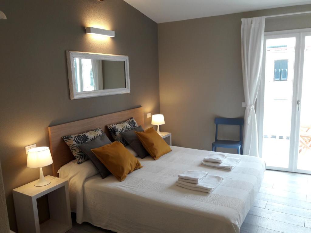 sypialnia z łóżkiem z 2 lampami i lustrem w obiekcie Santa Marta Rooms - Vernazza w mieście Vernazza