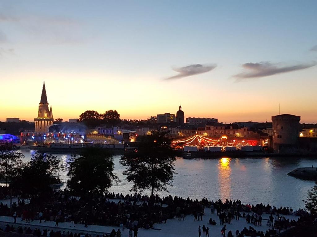 Un groupe de personnes debout autour d'une rivière au coucher du soleil dans l'établissement B&B La Difference, à Lagord