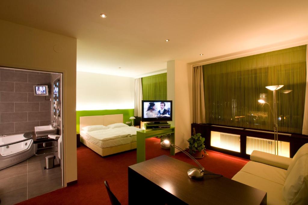 a hotel room with a bed and a tv at Hotel Restaurant Pusswald in Hartberg