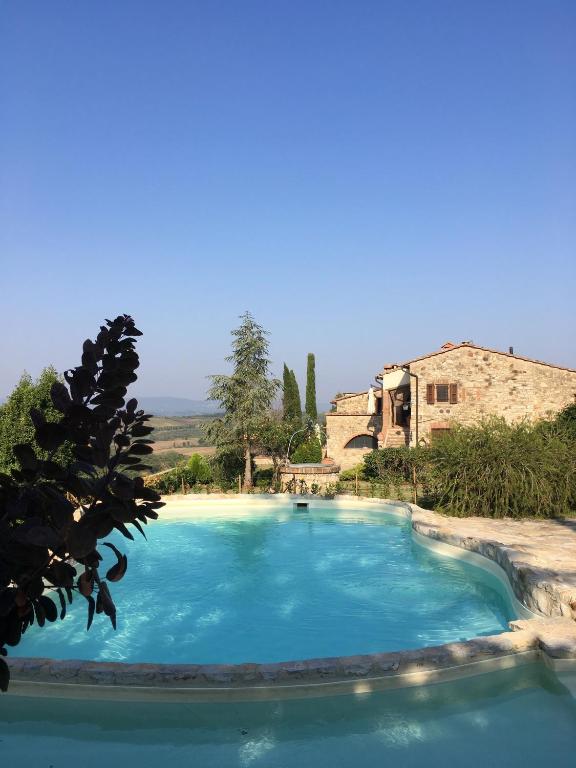 a swimming pool in front of a building at Residenza Cornino in Castellina in Chianti