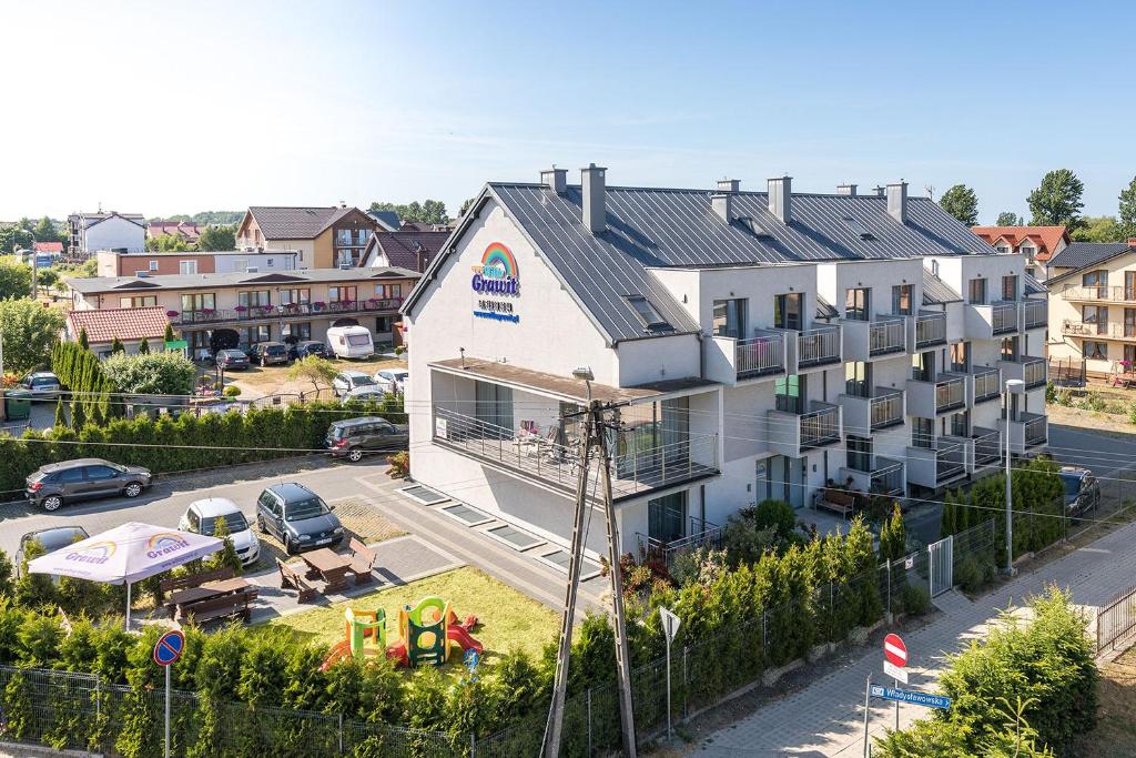 an apartment building with a playground in a parking lot at Willa Grawit in Władysławowo