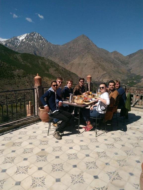 a group of men sitting at a table eating food at Toubkal Garden in Imlil