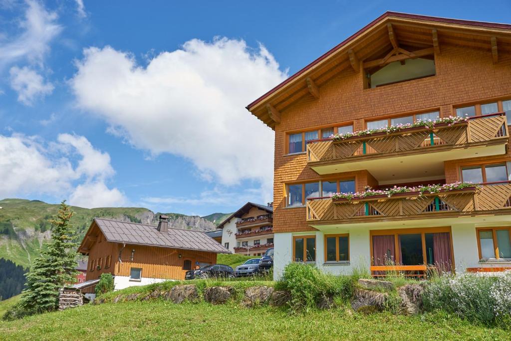 ein Haus auf einem Hügel mit Bergen im Hintergrund in der Unterkunft dr'Berghof in Damüls