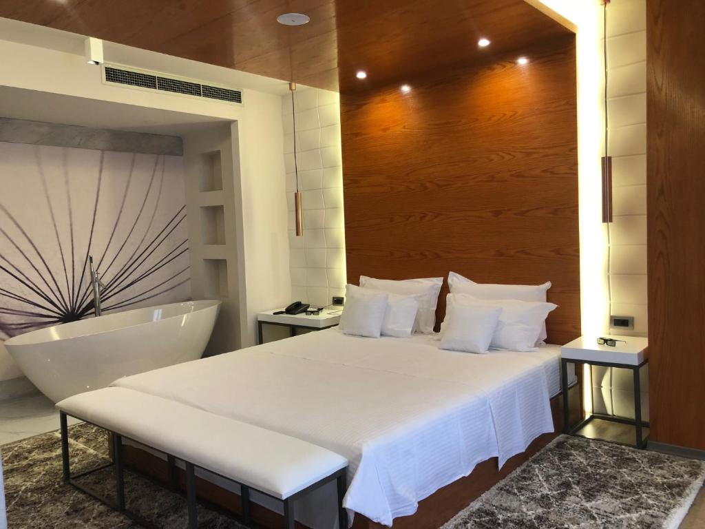 ein Schlafzimmer mit einem großen Bett und einer Badewanne in der Unterkunft Hotel Palace in Vlorë