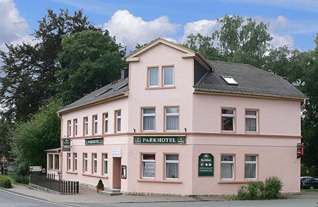 a large pink building on the side of a street at Pension "Parkhotel" Blankenhain in Blankenhain