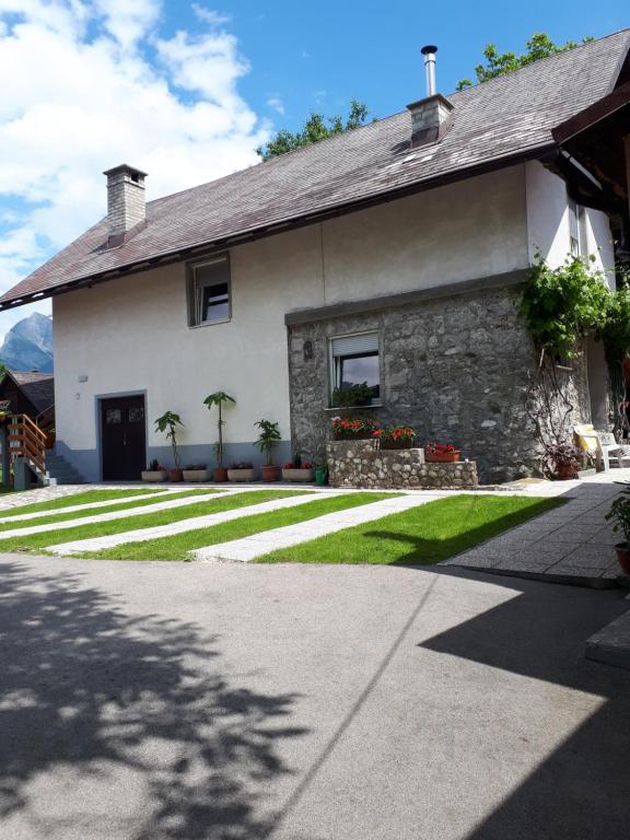 a house with a grass yard in front of it at Apartments Lenc in Bovec