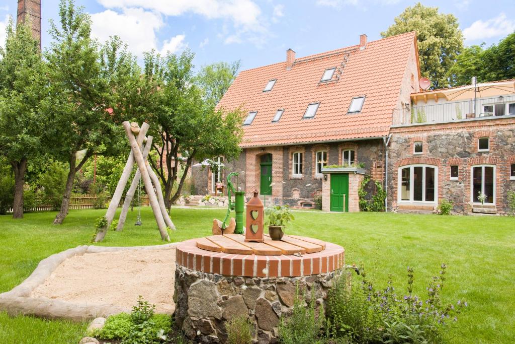 ein Haus mit einem Spielplatz vor einem Hof in der Unterkunft Ferienwohnungen im Alten Backhaus in Haselberg