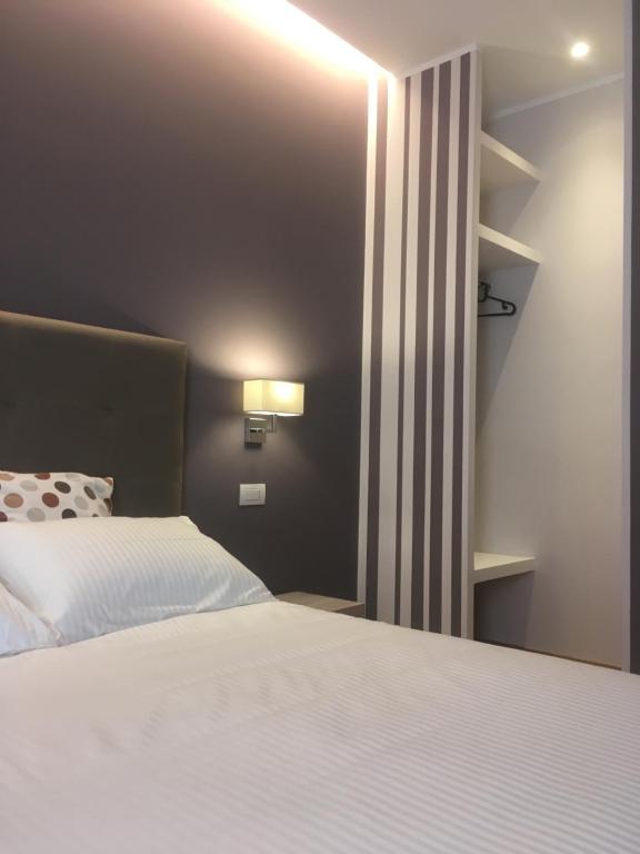 sypialnia z białym łóżkiem i oknem w obiekcie Robin Rooms w mieście Montegranaro