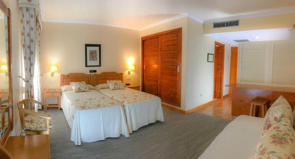 A bed or beds in a room at Hotel Spa Bosque mar