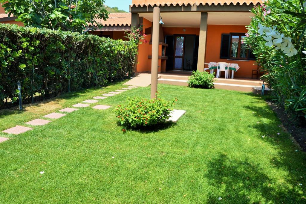 a yard with an orange house with a garden at Villetta Amare Sardegna in Costa Rei