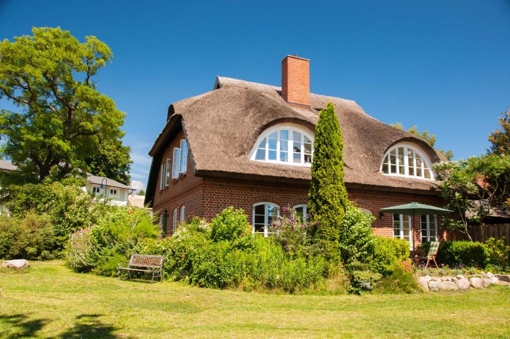 ミデルハーゲンにあるLandhaus am Deichの茅葺き屋根の大きなレンガ造りの家