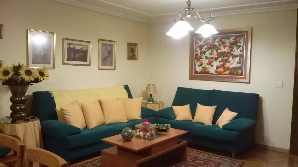ein Wohnzimmer mit einem blauen Sofa und einem Tisch in der Unterkunft Habitacion Privada en Piso Familiar in Pontevedra