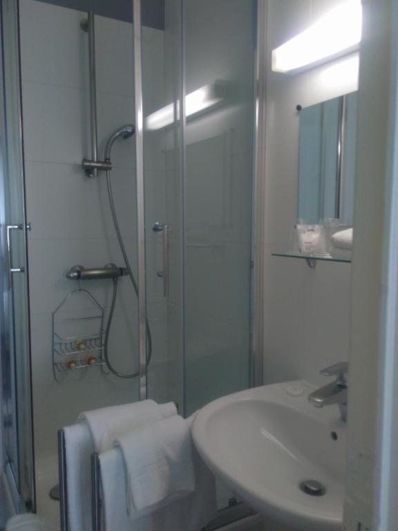 a bathroom with a glass shower and a sink at Eurotel in Liège
