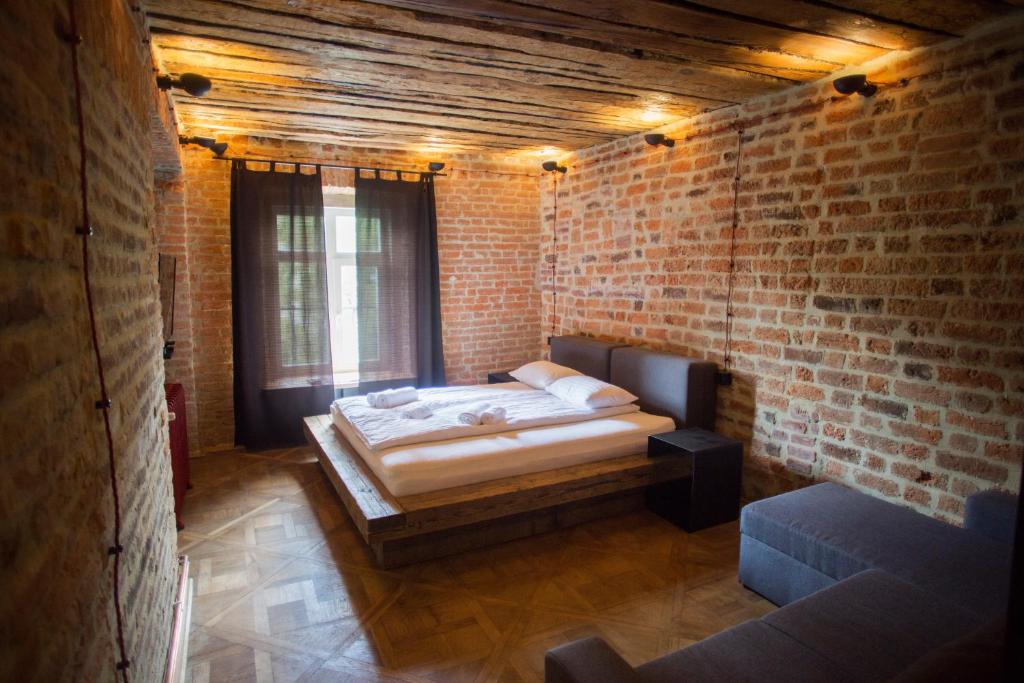 um quarto com uma cama numa parede de tijolos em Vysoka Khata1 em Lviv