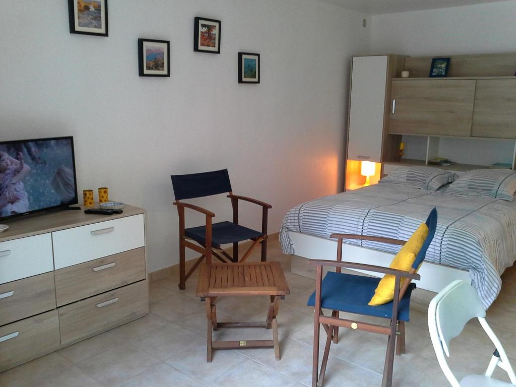 - une chambre avec un lit, deux chaises et une télévision dans l'établissement d17 studio pietra, à Mucchio