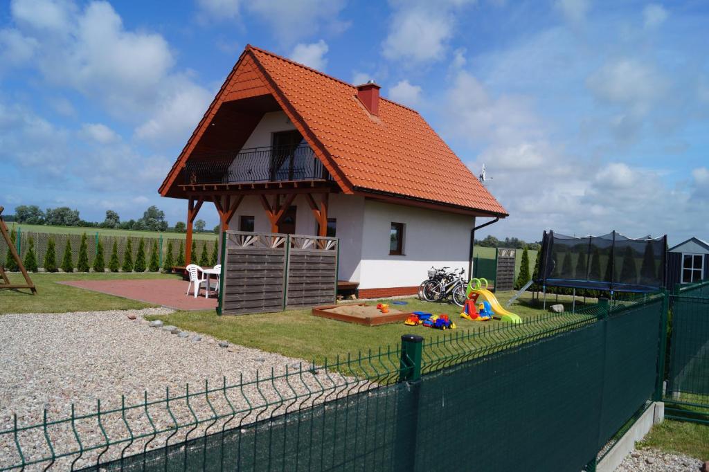 a small house with an orange roof and a playground at Domki Alex I Maciek in Pleśna