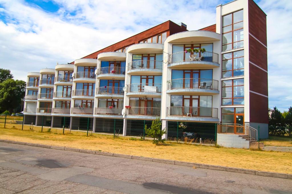 an apartment building with balconies on the side of a street at Vienas po kitu in Šventoji