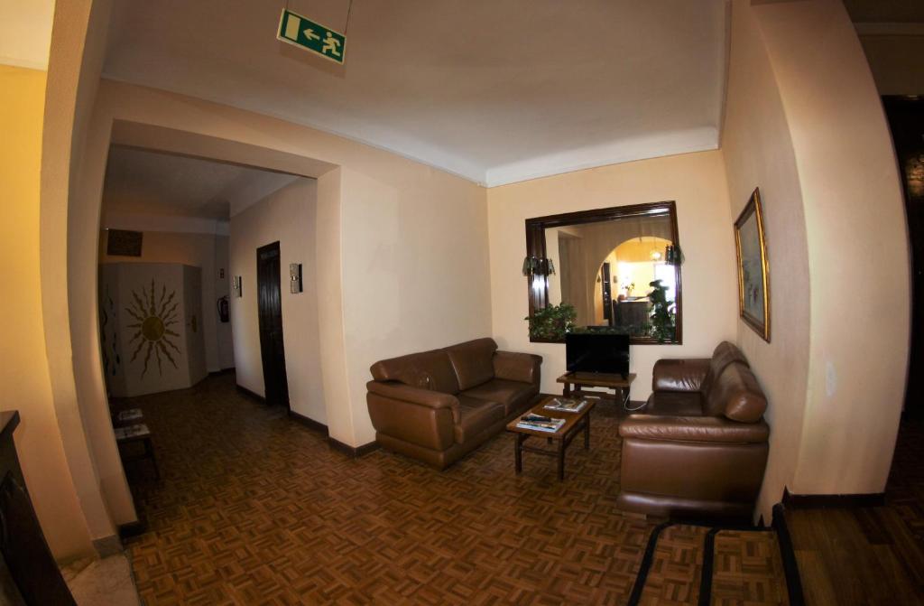 a living room with leather furniture and a mirror at Residencial Sol in Portimão