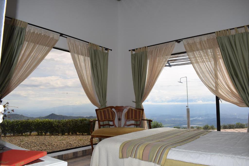 sypialnia z łóżkiem i dużymi oknami w obiekcie Monte Abi Mirador w mieście Chaguaní