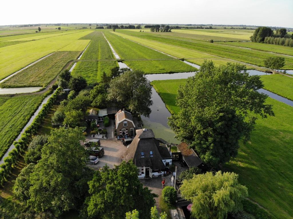 uma vista aérea de uma casa no meio de um campo em De Ouwe Meulen em Bleskensgraaf