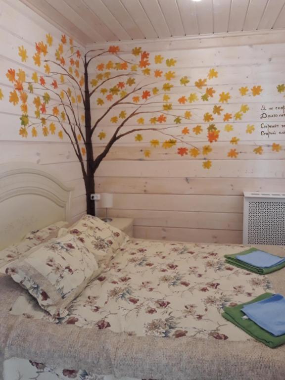 a bedroom with a tree mural on the wall at Vacation home in Konstantinovo in Konstantinovo
