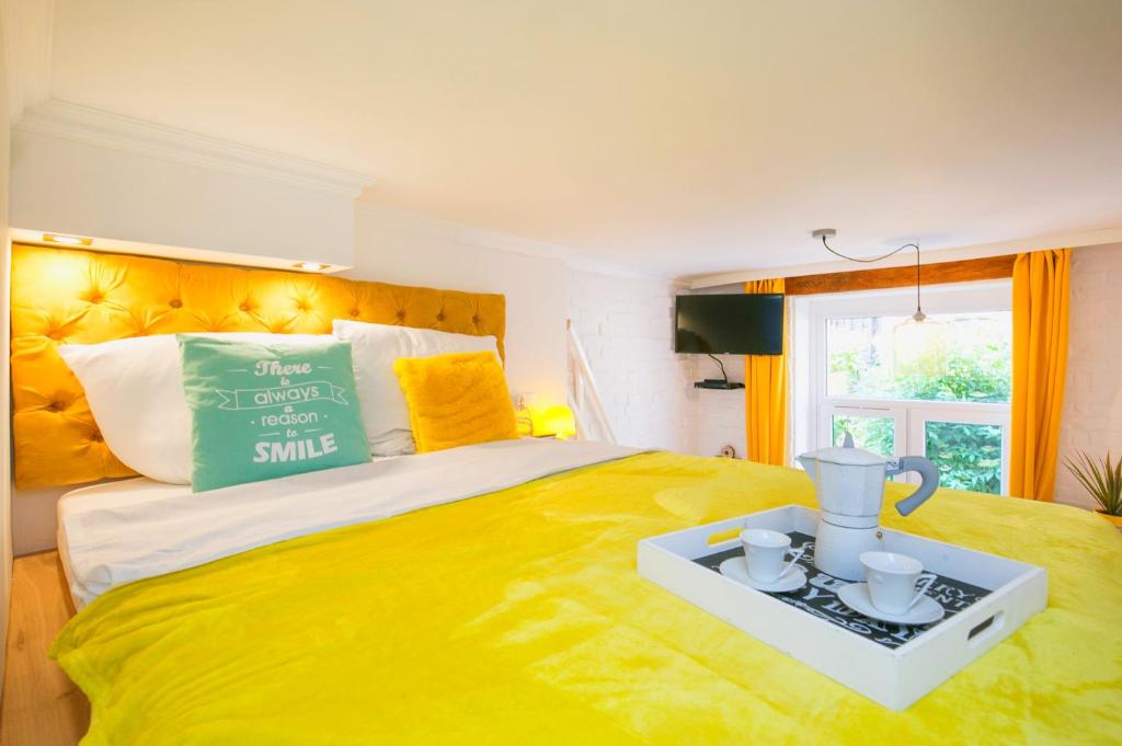 ein Schlafzimmer mit einem gelben Bett und einem Tisch darauf in der Unterkunft BERG Apartament YELLOW GDANSK in Danzig