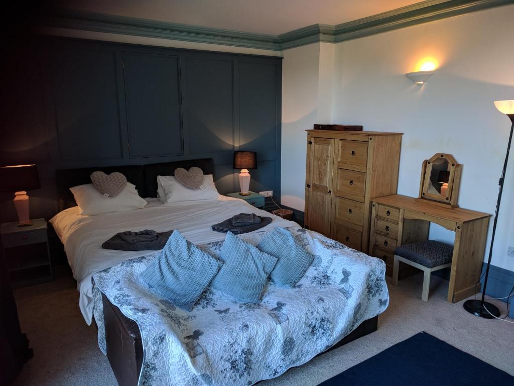 Un dormitorio con una cama con almohadas azules. en The Old Rectory, en Amlwch