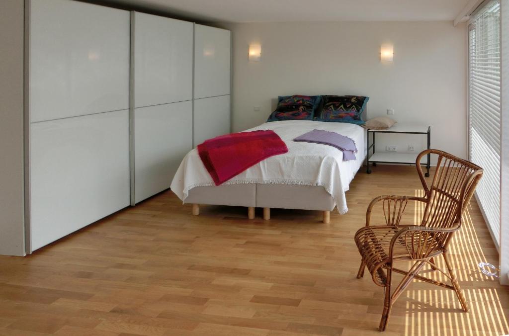a bedroom with a bed and two chairs in it at Modernes, sonniges Appartement im Herzen von Düsseldorf in Düsseldorf
