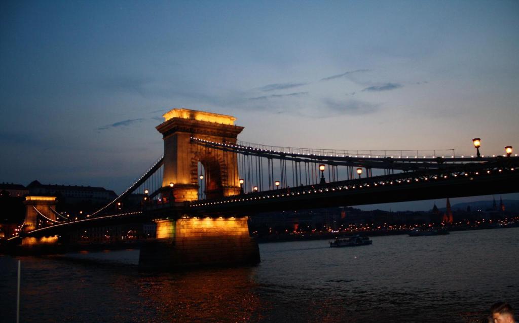 uma ponte iluminada sobre a água à noite em Elite Rooms & Apartments em Budapeste