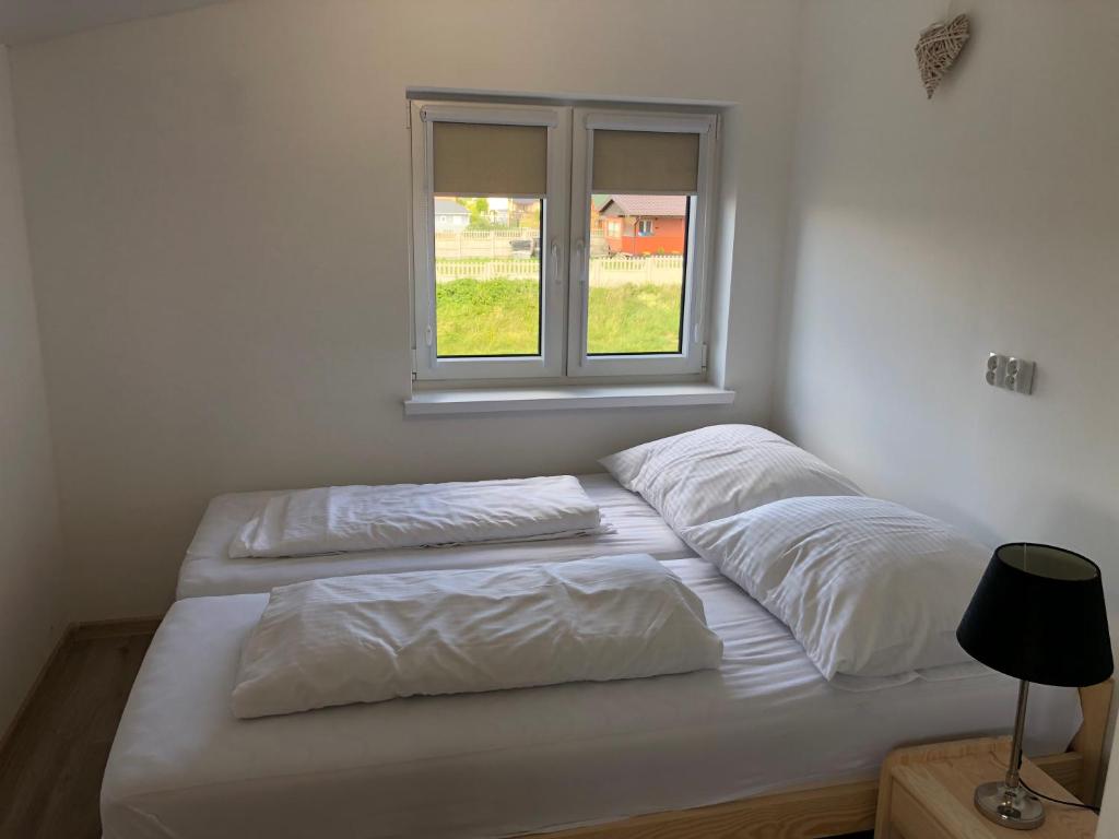 Postel nebo postele na pokoji v ubytování Apartamenty Tęczowa 14 Sarbinowo