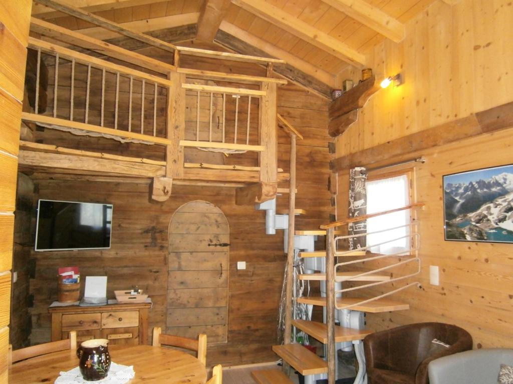 a cabin with a loft bed and a spiral staircase at Les Chalets du Bonheur in Les Houches