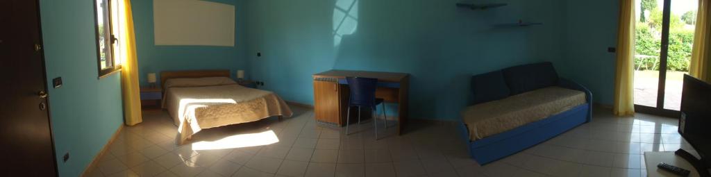 a blue room with two beds and a couch at Hotel Ristorante Al Canto delle Sirene in Terracina