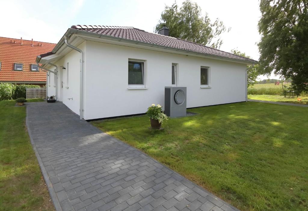 una pequeña casa blanca con un patio de césped en Ferienhaus Annemiete, en Putbus