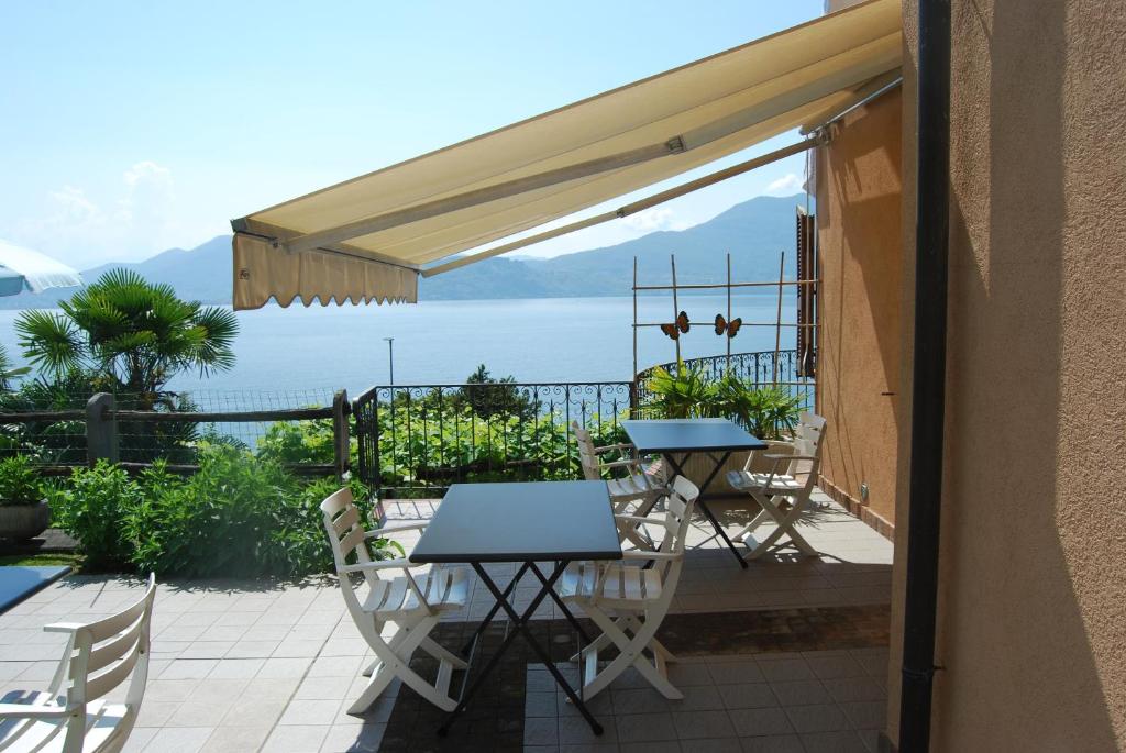 een patio met tafels en stoelen en uitzicht op de oceaan bij B&B Nonno Leo in Cannero Riviera