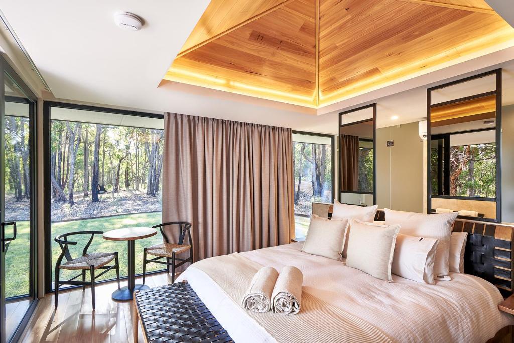 a bedroom with a large bed with a wooden ceiling at Amaroo Retreat & Spa in Mount Helena
