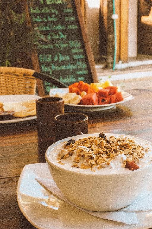 a bowl of food on a table with a plate of fruit at Makao Beach Hotel in Palomino