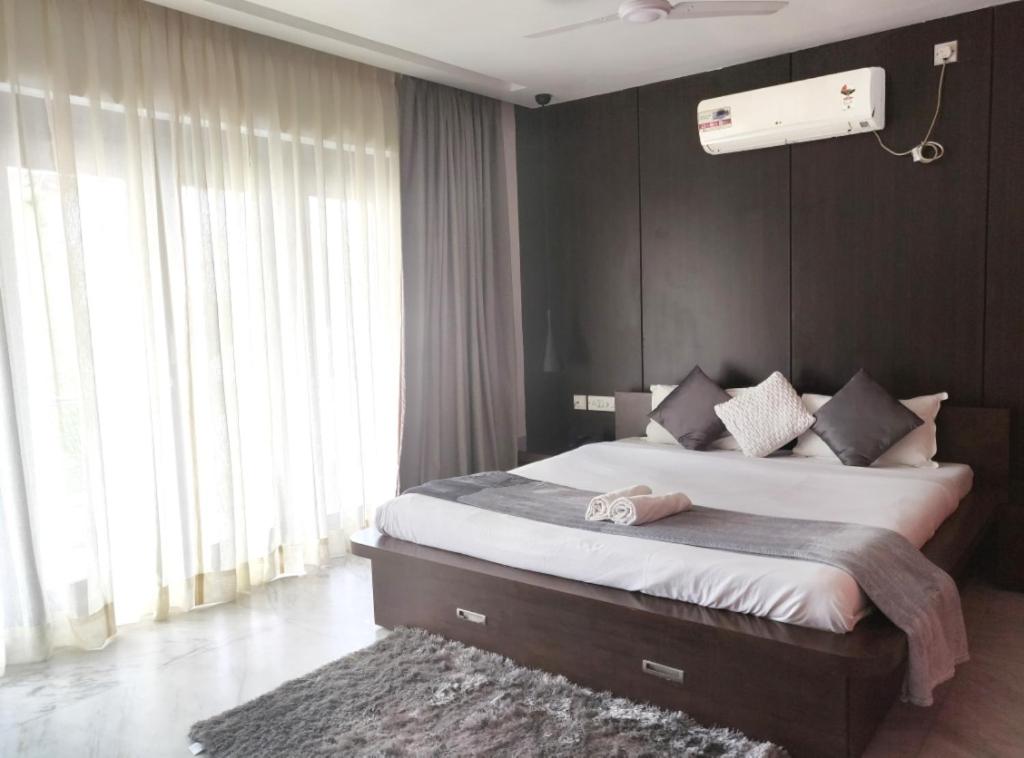 a bedroom with a large bed and a large window at Tatvam Residency in Kolkata