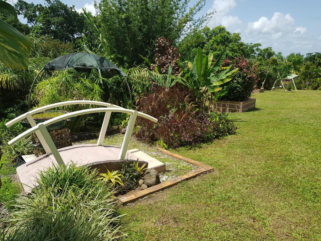 un jardín con una sombrilla en el césped en Domaine de Valcine, en Sainte-Rose