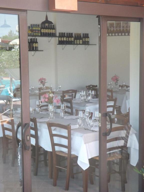 a dining room with tables and chairs with white tablecloths at Hotel Ristorante Al Canto delle Sirene in Terracina