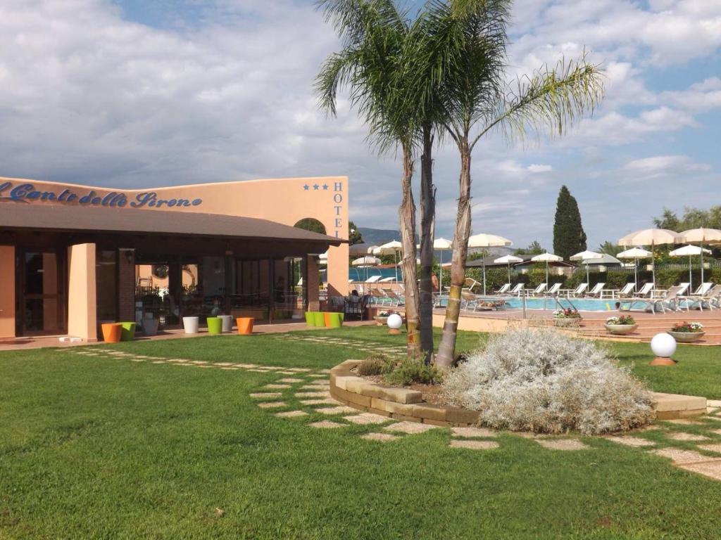 a resort with a palm tree and a swimming pool at Hotel Ristorante Al Canto delle Sirene in Terracina