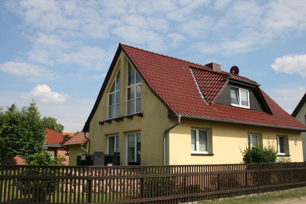 StraupitzにあるFerienhaus Straupitz-Spreewald mit Saunaの赤屋根の黄色い家