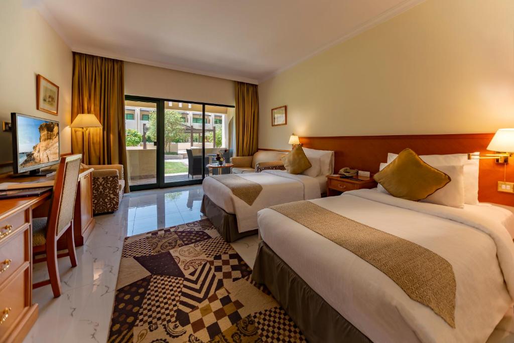 Postel nebo postele na pokoji v ubytování Golden Tulip Nizwa Hotel
