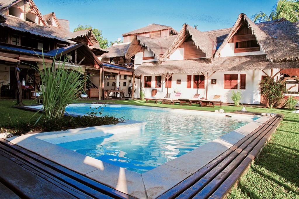 a swimming pool in front of a house at Villa Valiha Boutique Hotel in Ambatoloaka